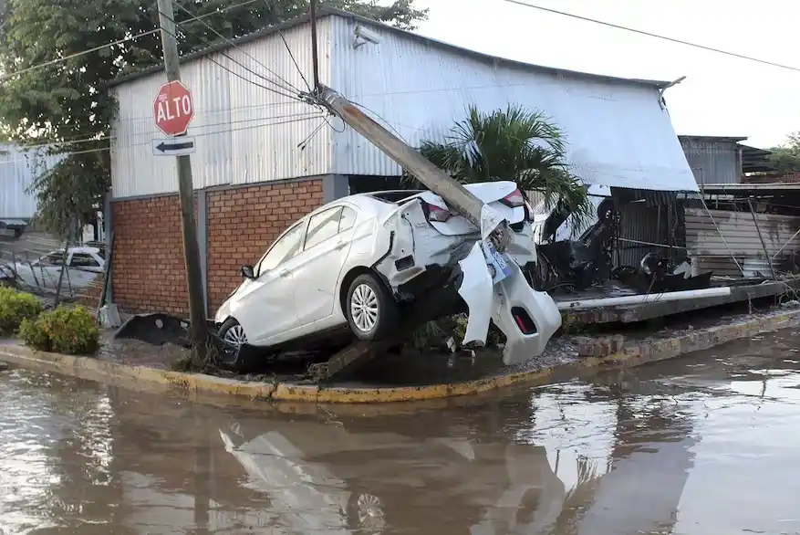 Un automóvil dañado en una calle inundada por las lluvias, en la ciudad de Poza Rica, en el estado de Veracruz, México