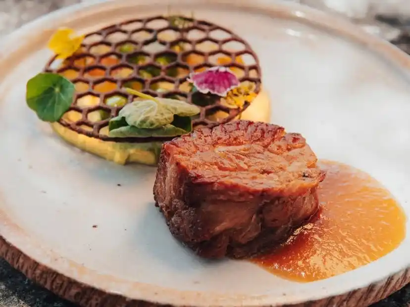 Ojo de bife a la parrilla, mole de berenjenas, chimichurri y ensalada criolla.