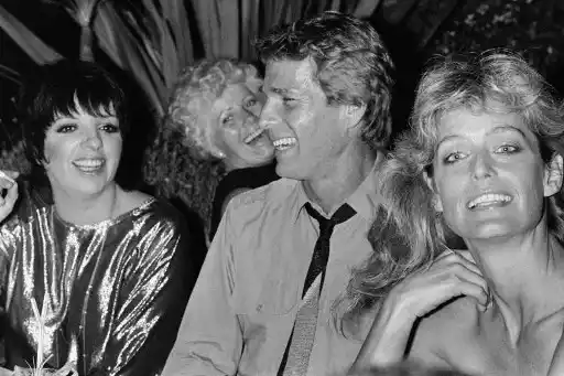 Ryan O'Neal entre Liza Minelli y su esposa, Farrah Fawcett. Foto AFP