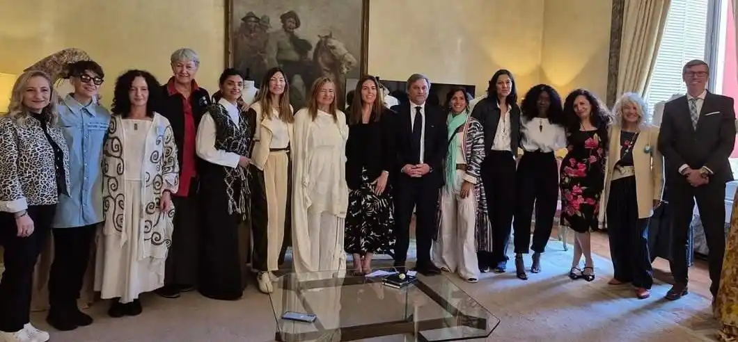 Las 8 diseñadoras y las organizadoras con funcionarios en la Embajada Argentina.-