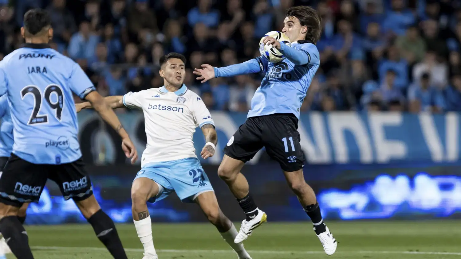 El tandilense González Metilli controla la pelota, seguido de cerca por Jara y Rojas.