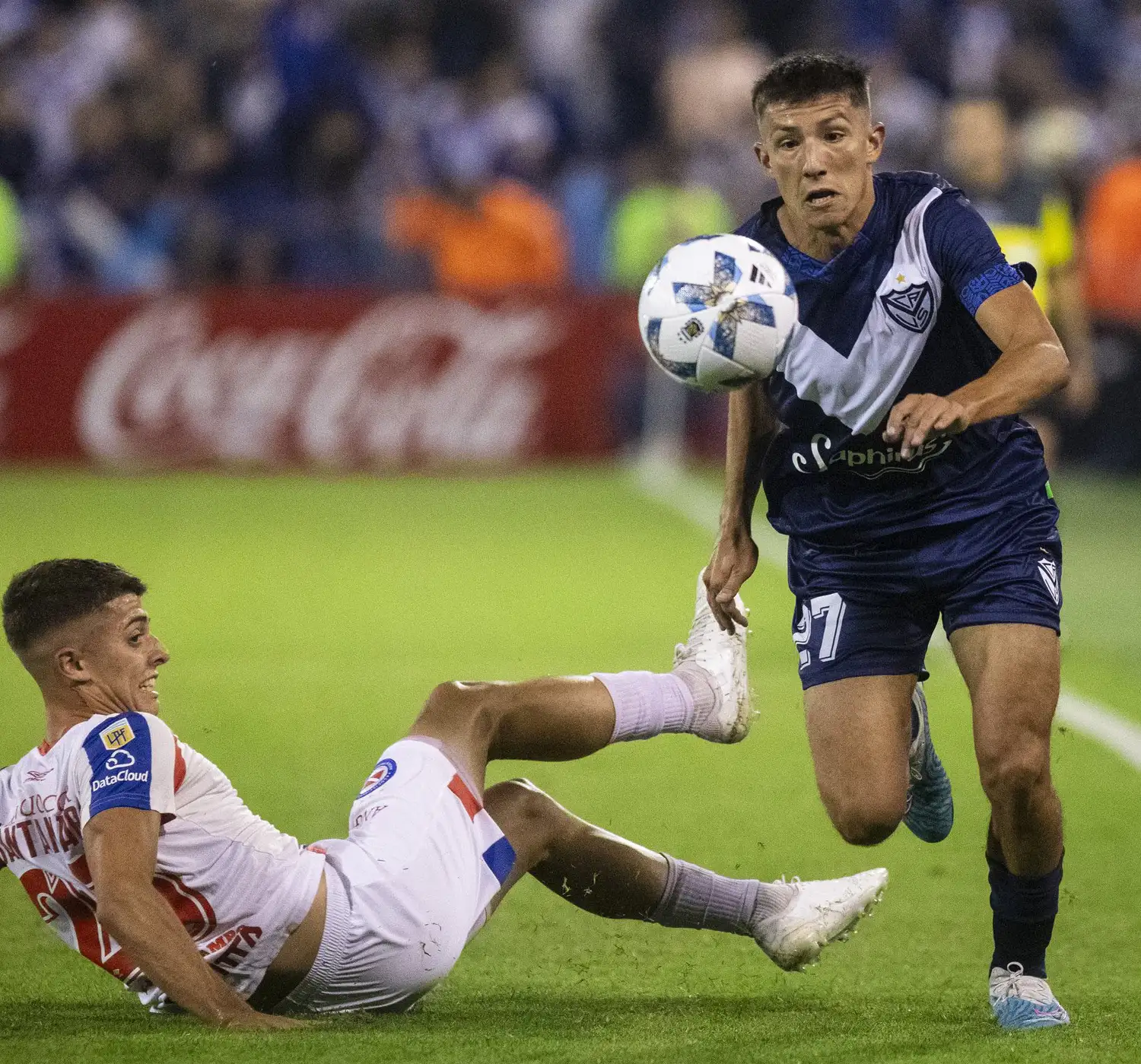 Desde el piso, Santamaría intenta frenar a Thiago Fernández.