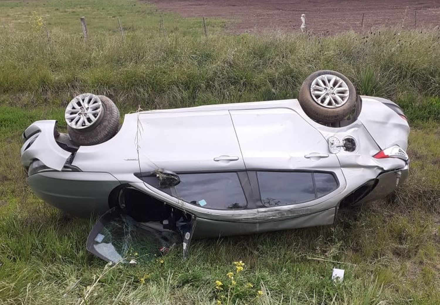 El auto terminó a un costado del camino con las ruedas apuntando al cielo.