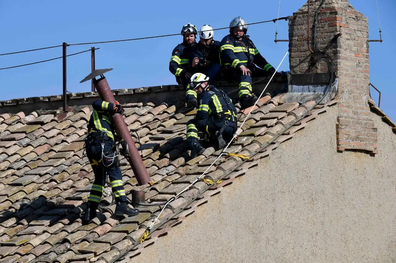 Unos cinco bomberos de la Santa Sede subieron al tejado del majestuoso edificio para colocar el humero .