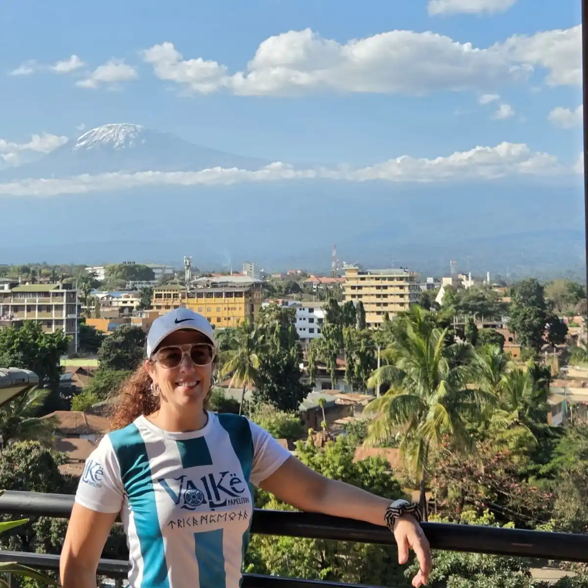 María Laura Broggri con la camiseta de Papelitos y la cumbre del Killimanjaro de fondo.