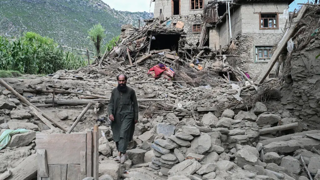 Un afgano pasa frente a una casa dañada por el terremoto en la aldea de Mazar Dara