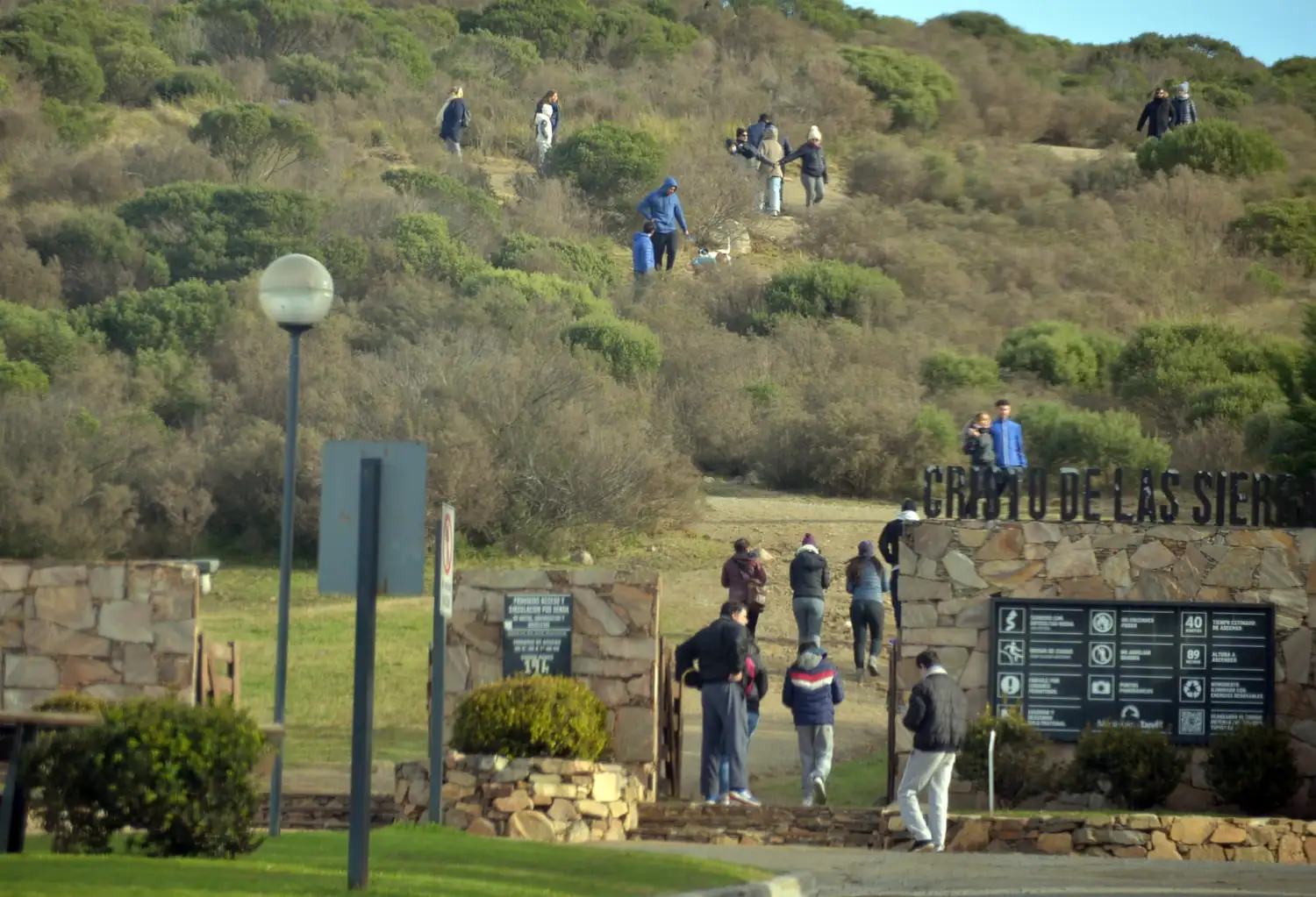 Vecinos y turistas en el ingreso al Cristo de las Sierras.