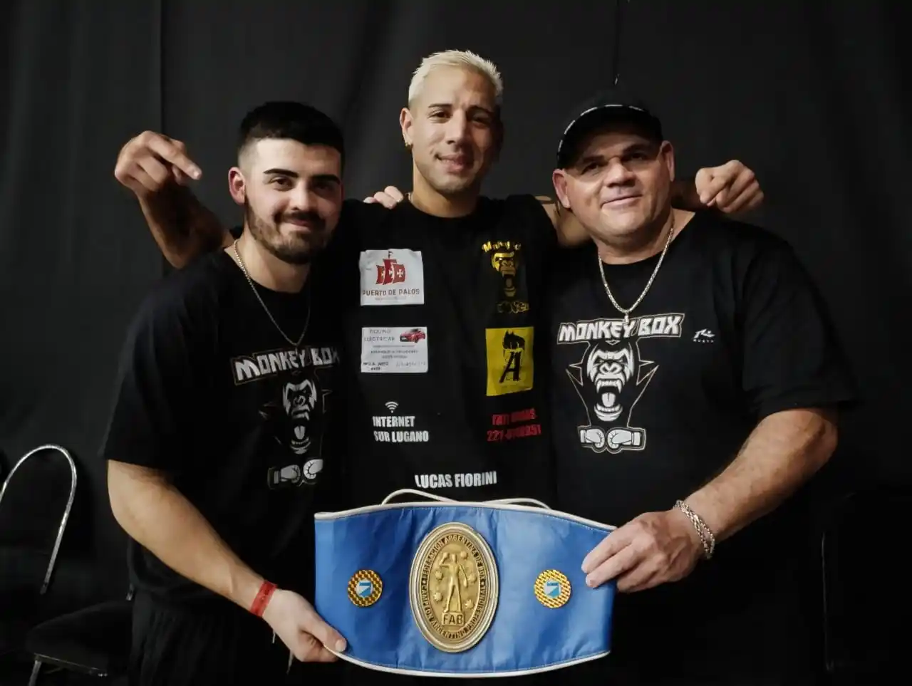 Lucas Bastida con el título argentino junto a su rincón.