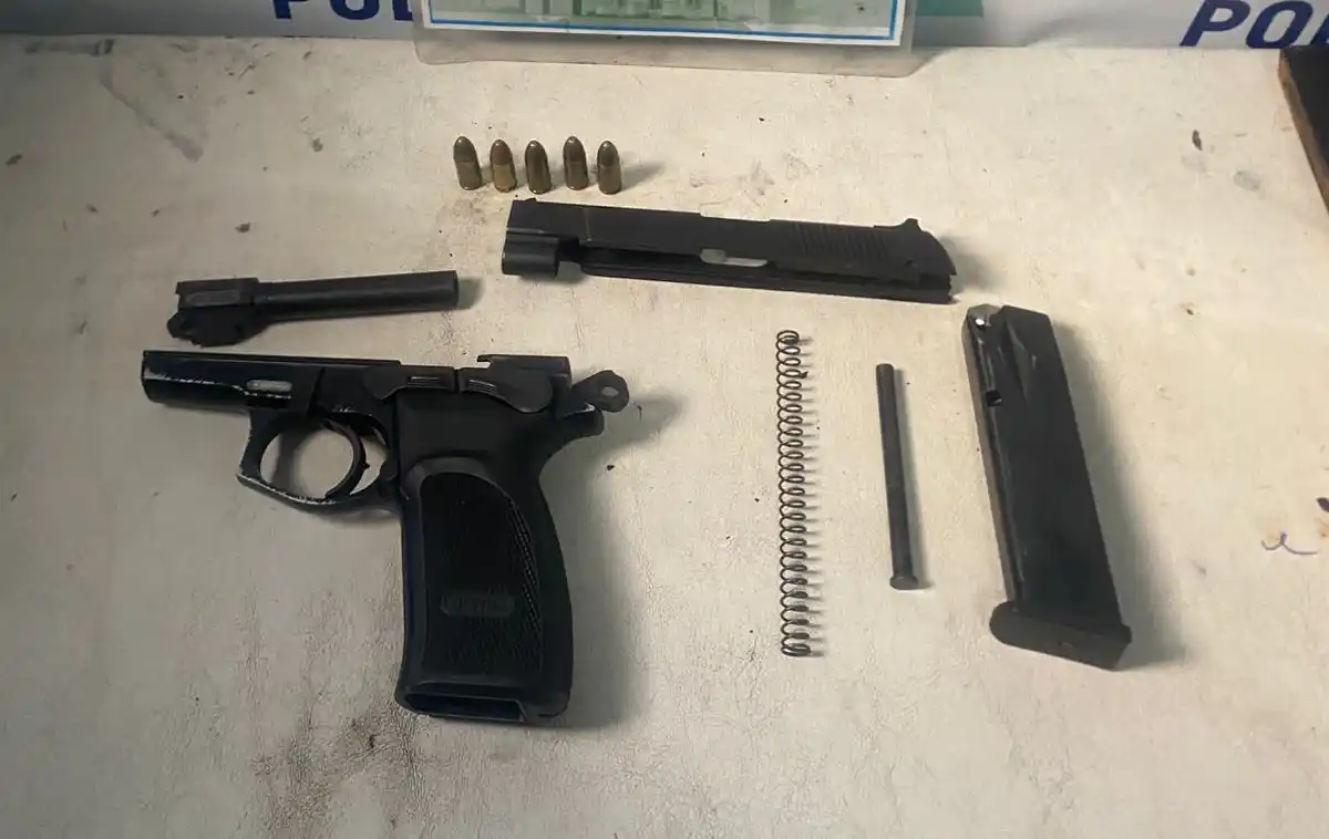 El arma y los cartuchos que secuestraron en poder de la joven.