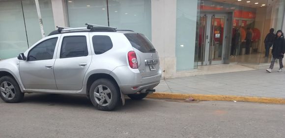Auto mal estacionado sobre ochava, línea amarilla y dársena de motos