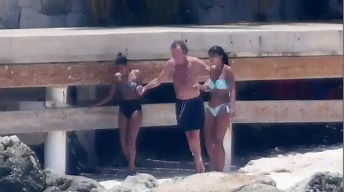 Dos jóvenes ayudan a Julio Iglesias a moverse por la playa de Punta Cana. Foto Sálvame