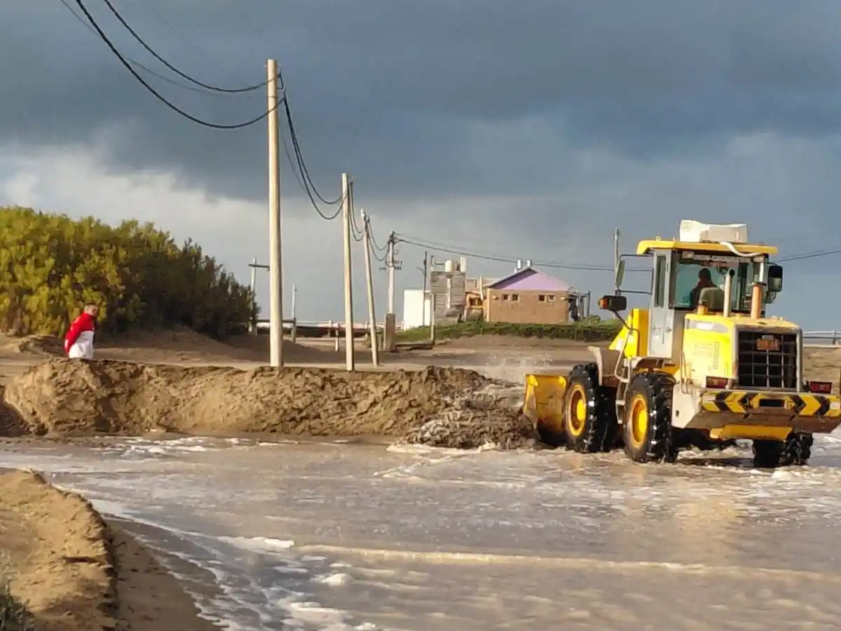 Maquinaria de la subdelegación creando una barrera de arena para frenar el agua de mar