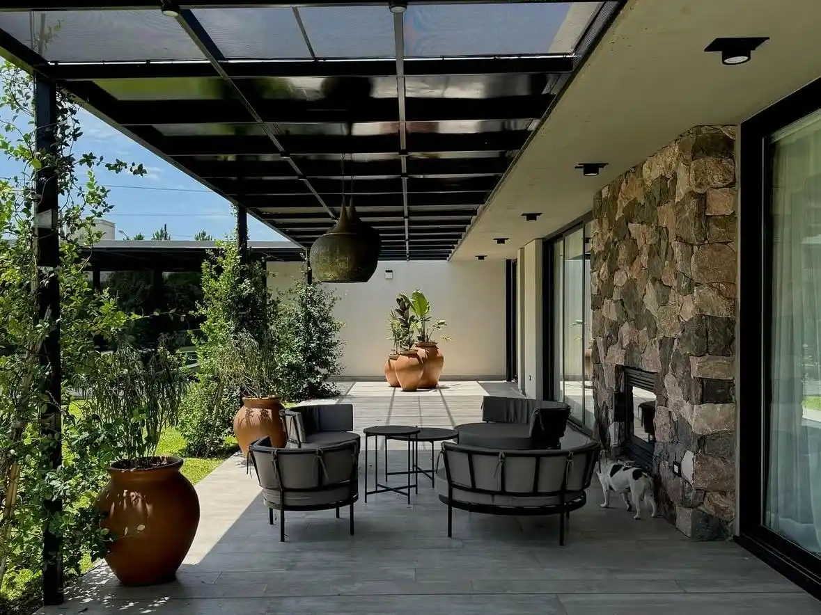 Galería con sector cerrado, con sillones y pérgola abierta al fondo. (Foto: Estudio Chelsea)