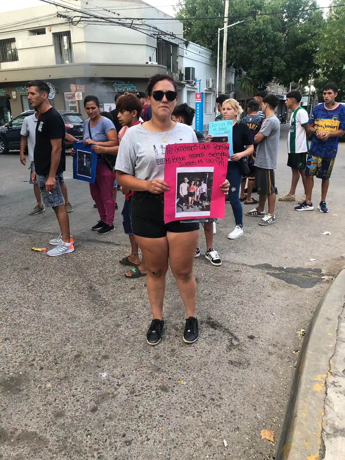 Una de las hermanas de Lautaro y su pancarta pidiendo justicia en las puertas de la casa velatoria.