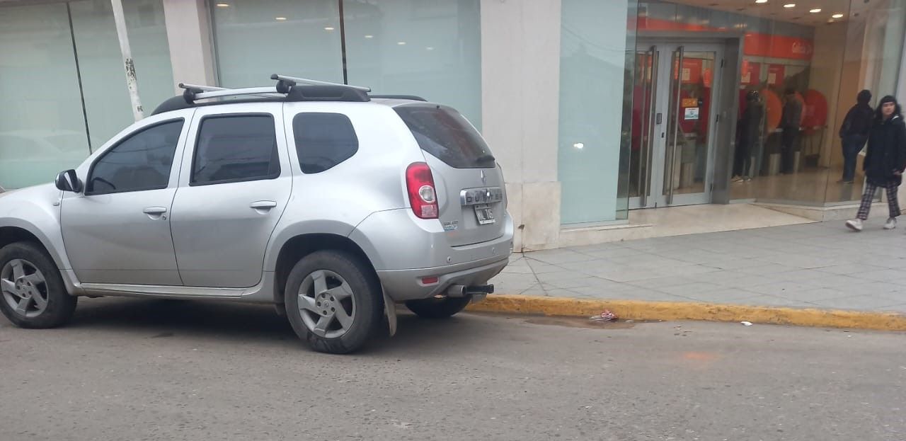 Auto mal estacionado sobre ochava, línea amarilla y dársena de motos