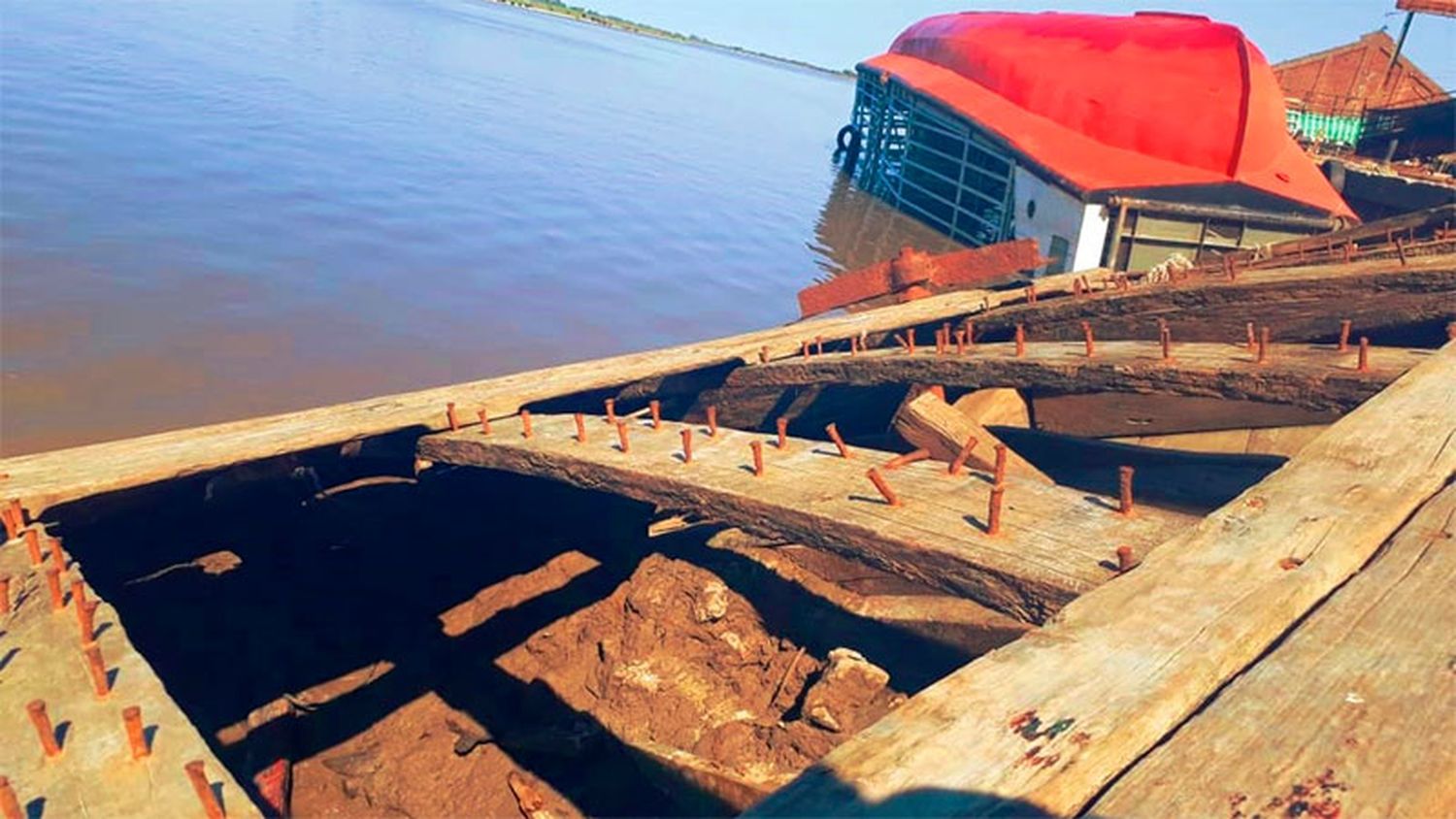 Antigua barcaza hundida en puerto quedó a la vista por la bajante del río: fotos