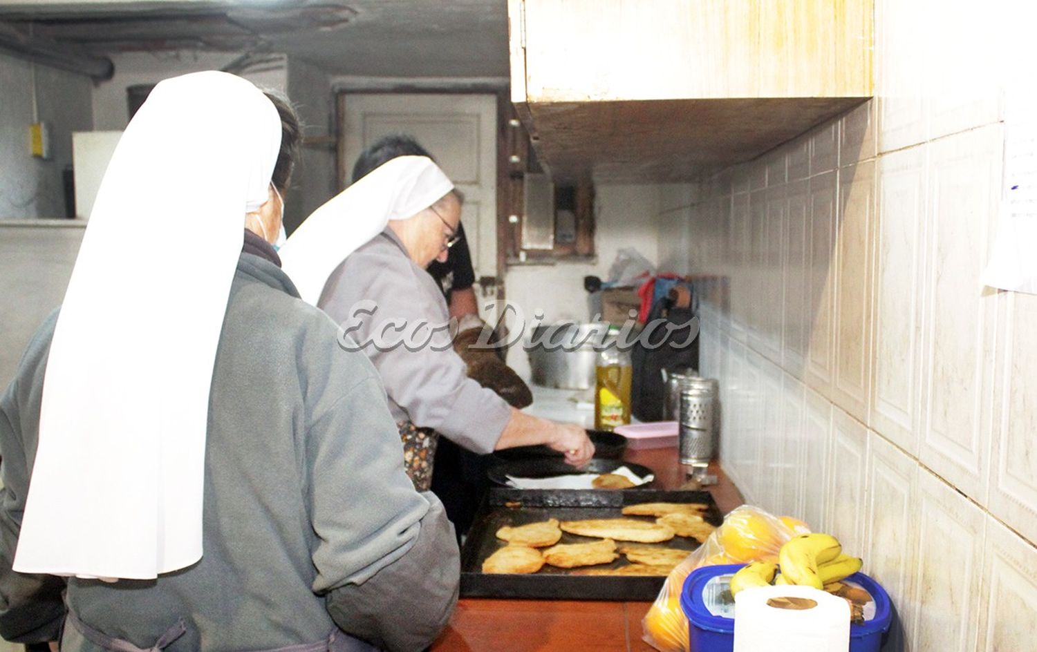 Voluntarios. Una pareja y dos religiosas cocinando