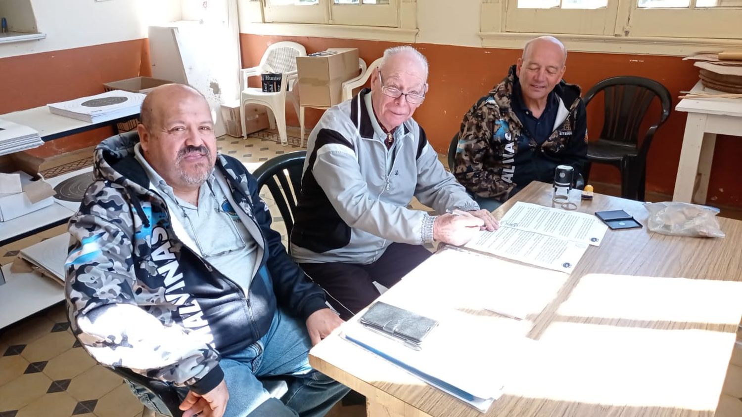 Héctor Murúa y Héctor Almada, secretario y presidente del  Centro de Veteranos de Guerra Islas Malvinas, respectivamente,  firmando el convenio con el Tiro Federal de Tandil representando por su presidente Ricardo Weidmann.