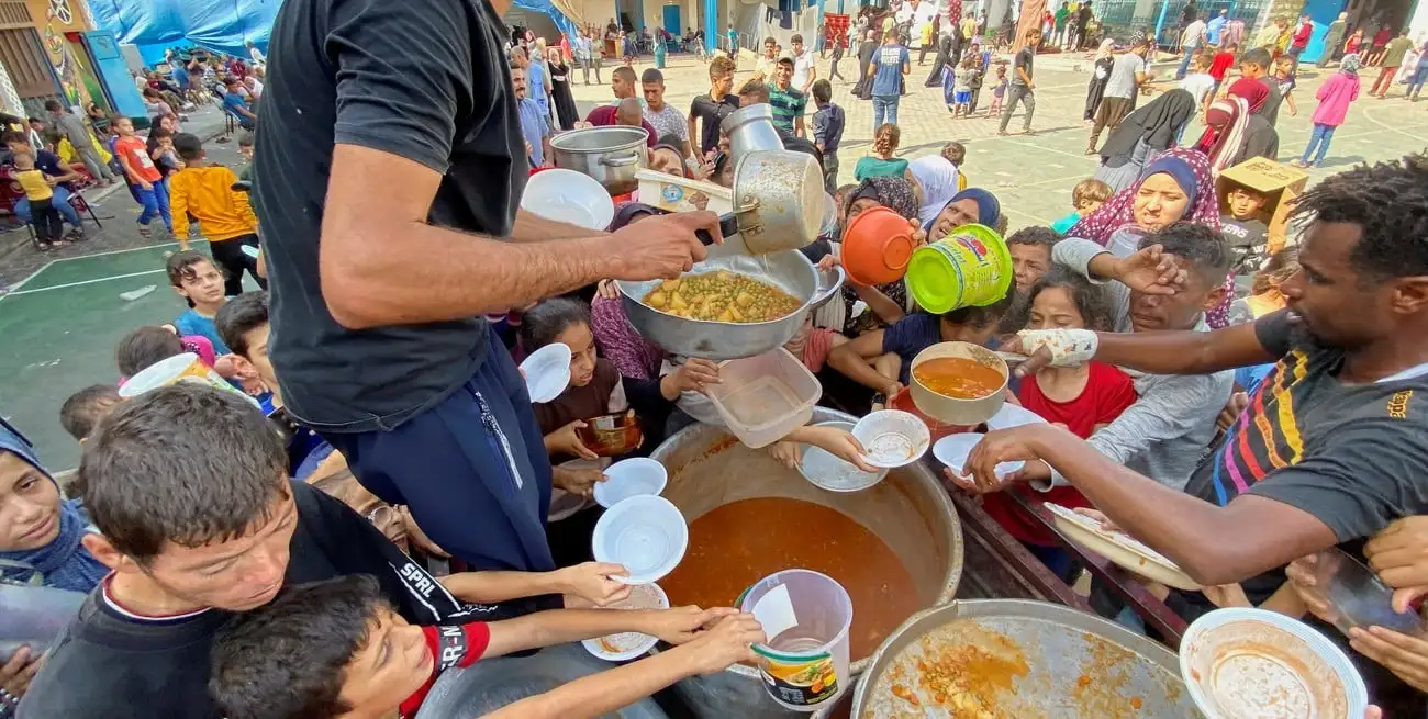 Palestinos se reúnen para recibir su parte de alimentos benéficos ofrecidos por voluntarios. Foto: Reuters