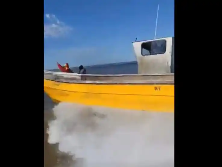 Una embarcación de la Armada se acerca a una de las barcas, que hacen caso omiso al llamado a detenerse.