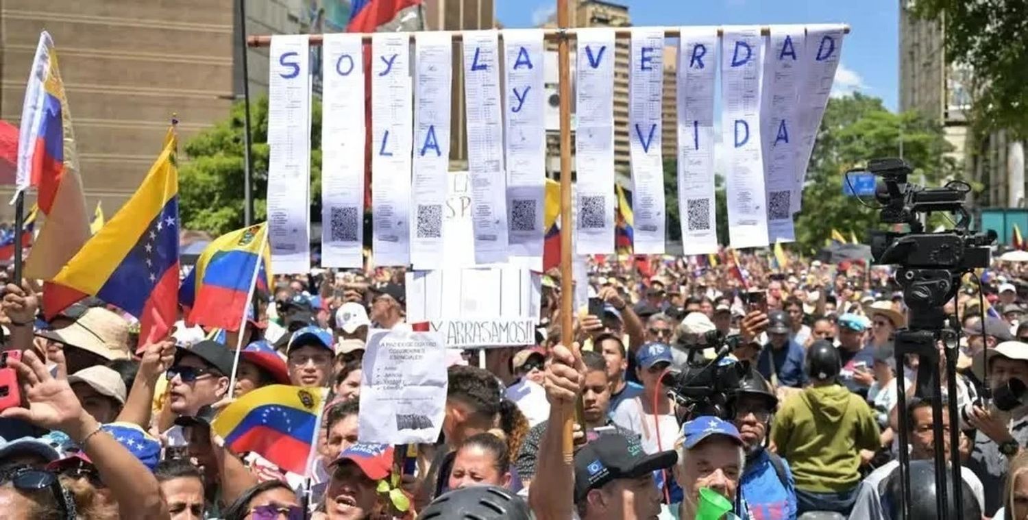 Manifestantes reclaman en Caracas por "la verdad" y "la vida" que se reconozca la victoria opositora en Venezuela. El pueblo muestra constancias del voto a favor de la alianza opositora. La consigna: "¡Arrasamos!" Juan Barreto/AFP/DW