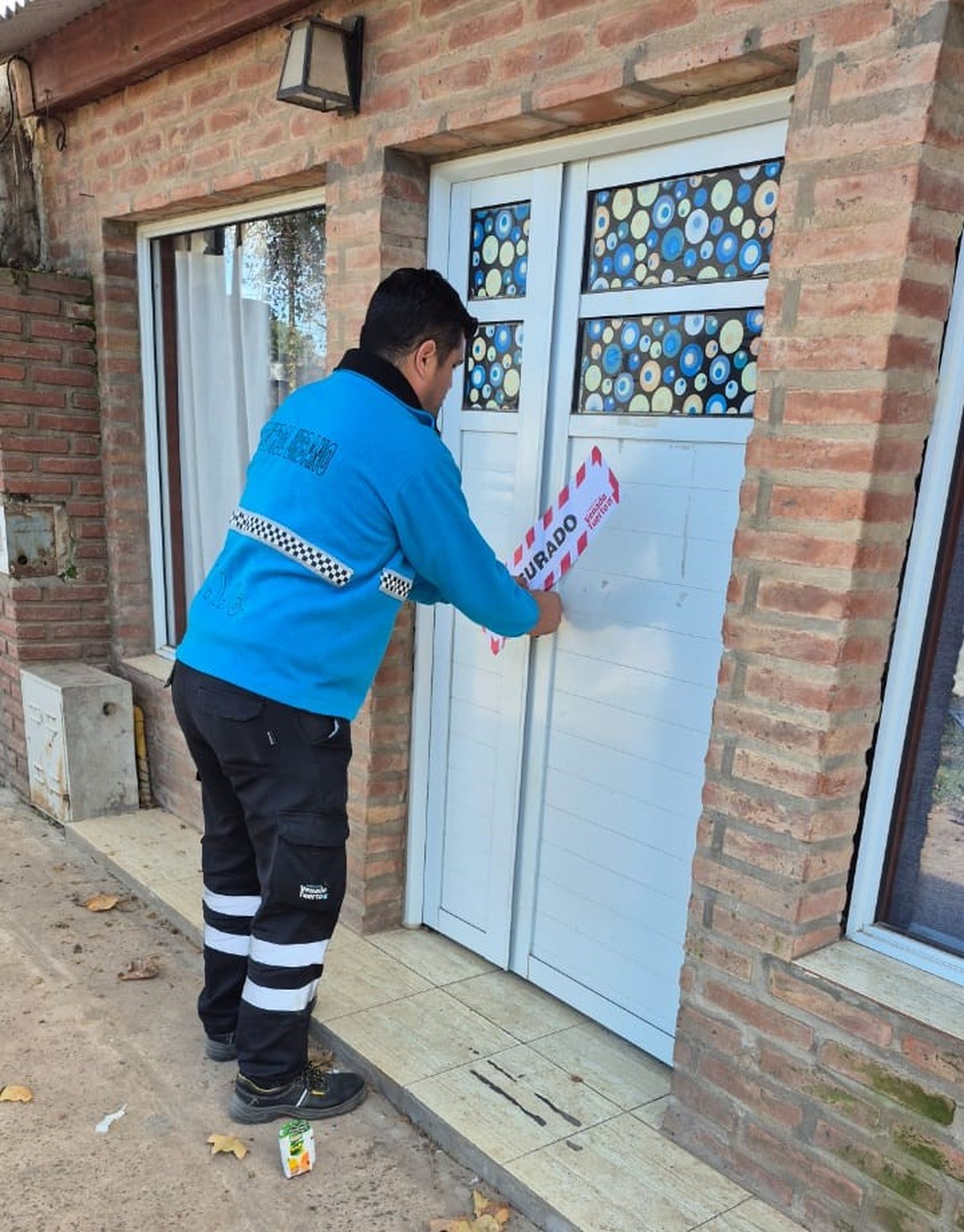 El momento en que personal policial procede a la clausura en el ingreso al inmueble.