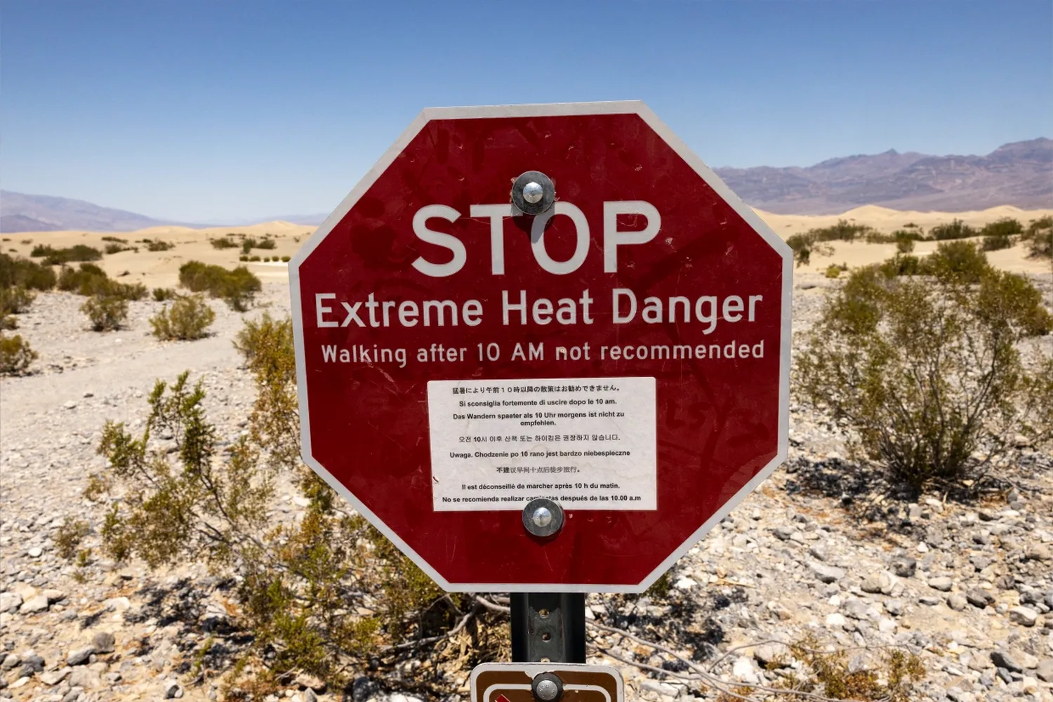 A sign reads "Stop Extreme Heat Danger" at Mesquite Flat Sand Dunes in Death Valley National Park near Furnace Creek during a heat wave affecting Southern California on Sunday.