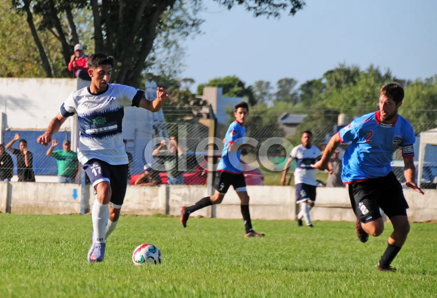 Ugarte (Gimnasia), pelota al pie ante Baier (Loma Negra).