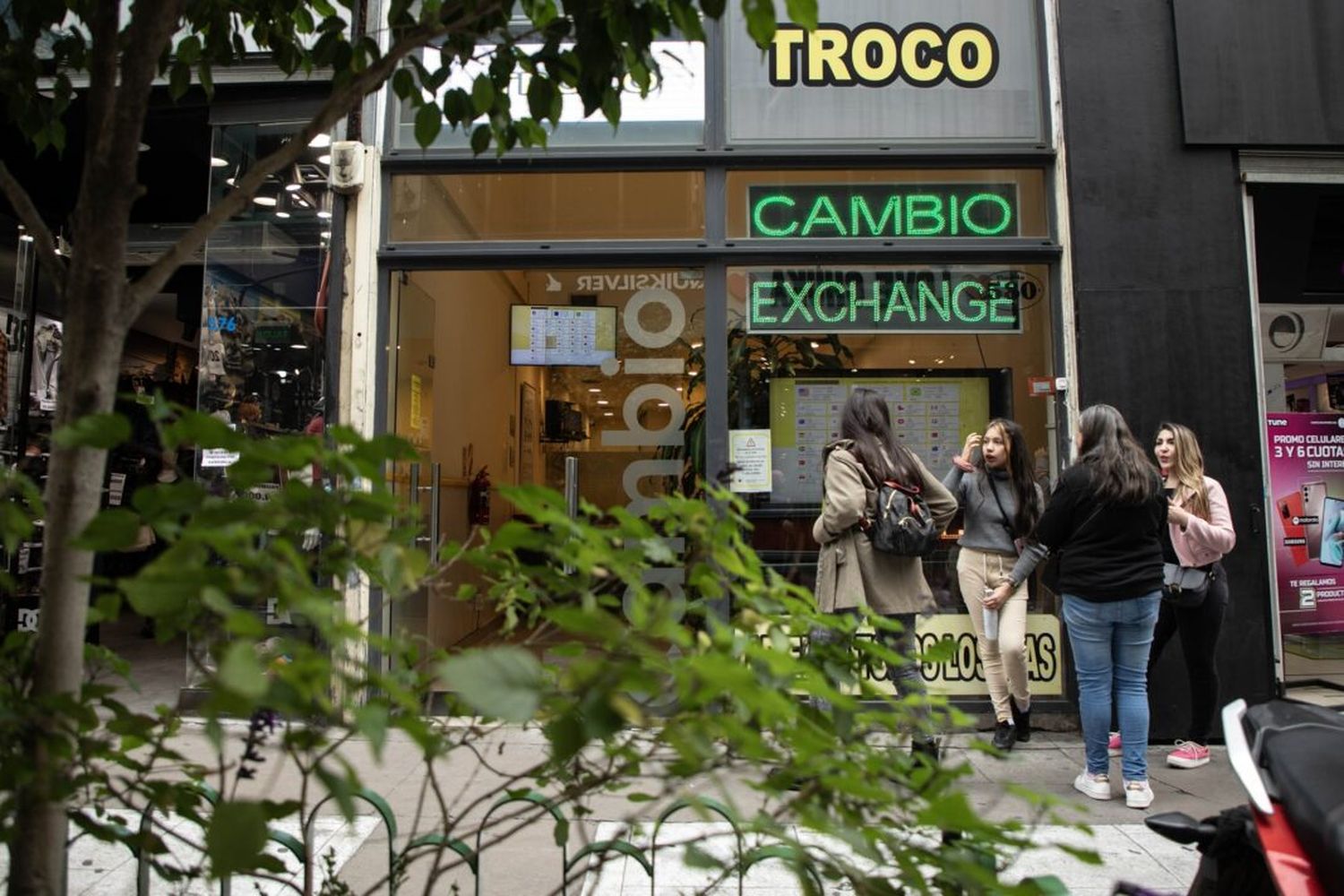 Personas conversan frente a un local de venta de divisas ubicado en el Microcentro