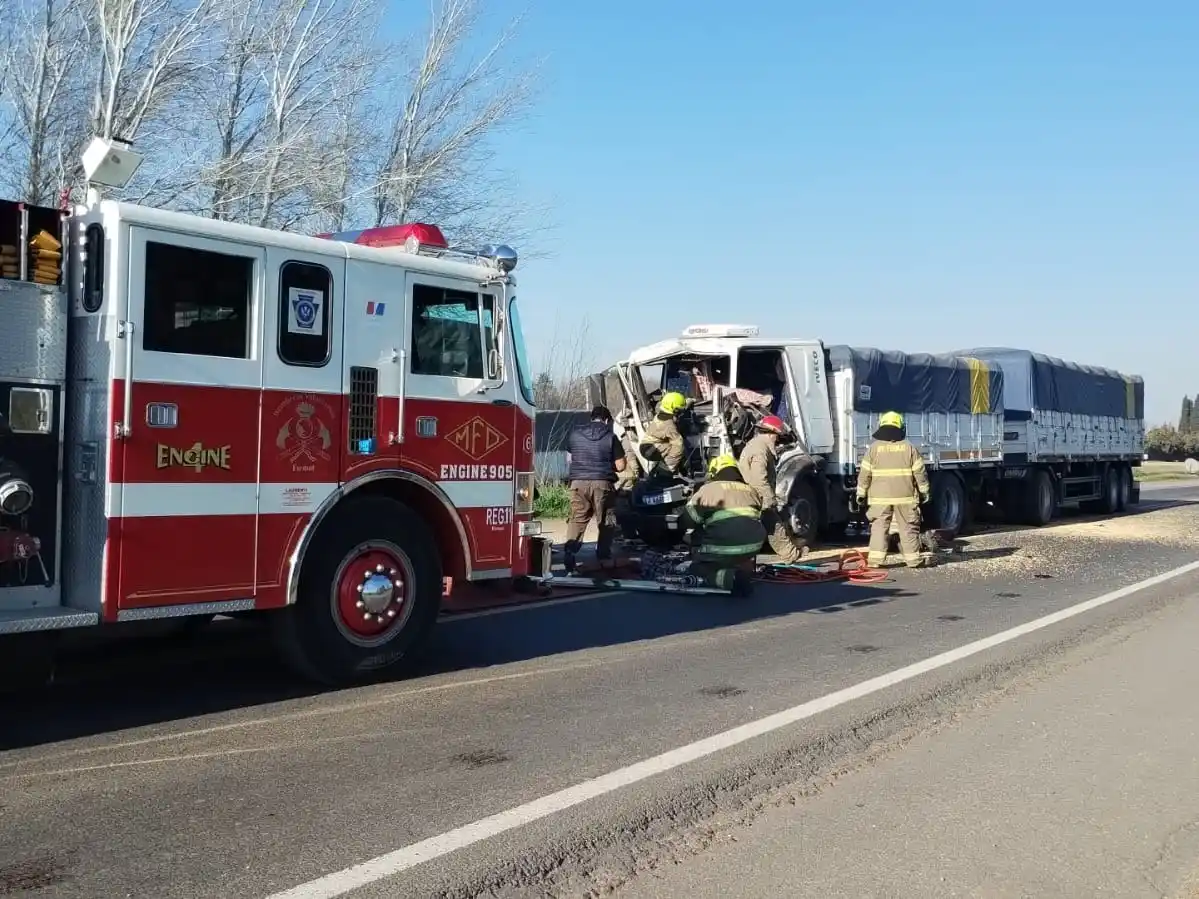 Personal de bomberos rescatando al chofer de la cabina.
