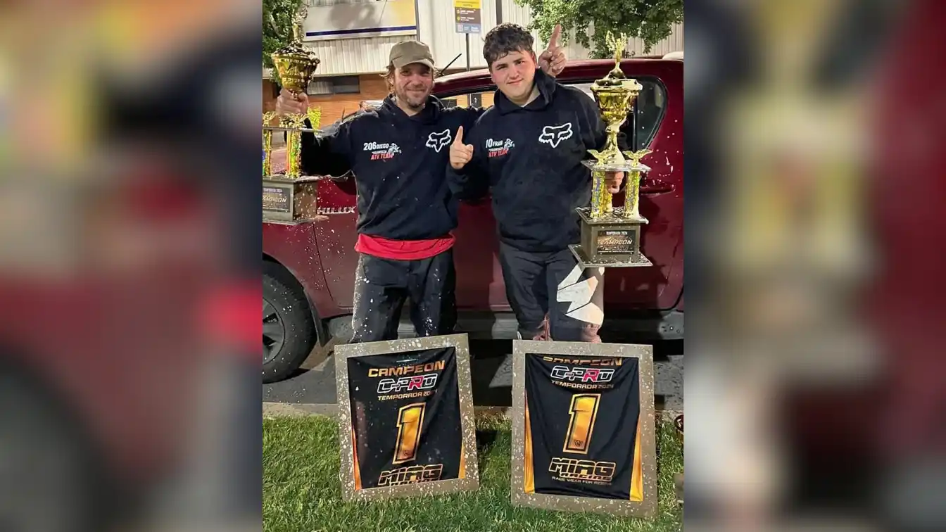 Padre e hijo con sus trofeos de campeones.