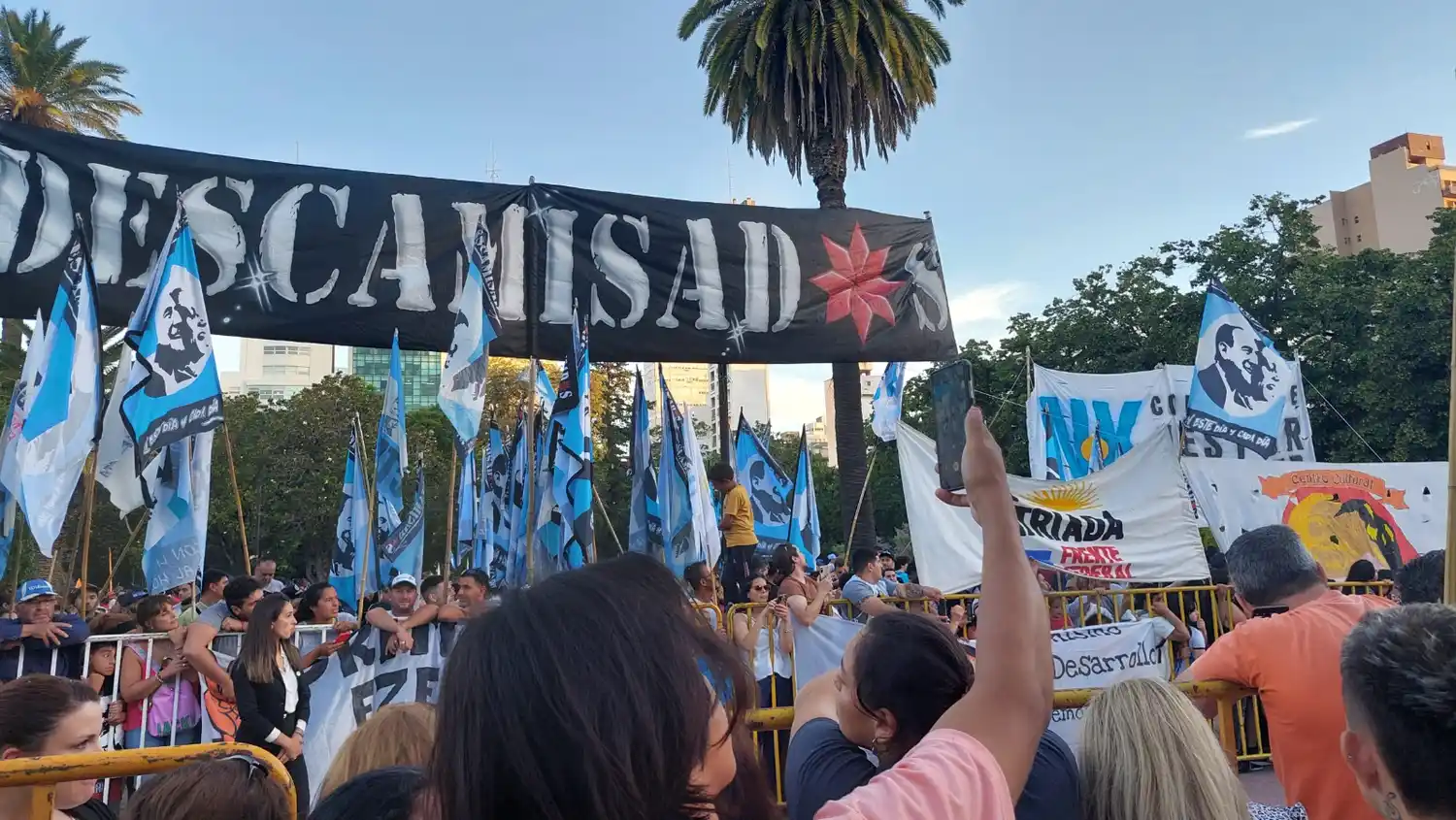 La gente espera tras las vallas para saludar al Gobernador.