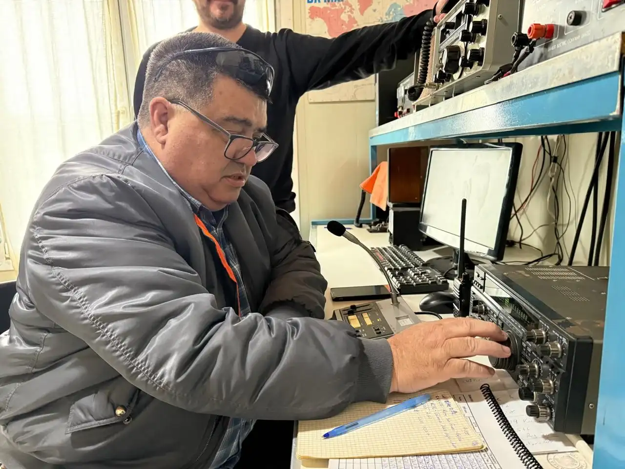 Fotografía de integrantes del Radio Club Tandil, en su nueva sede. Con equipos de radio aficionados.