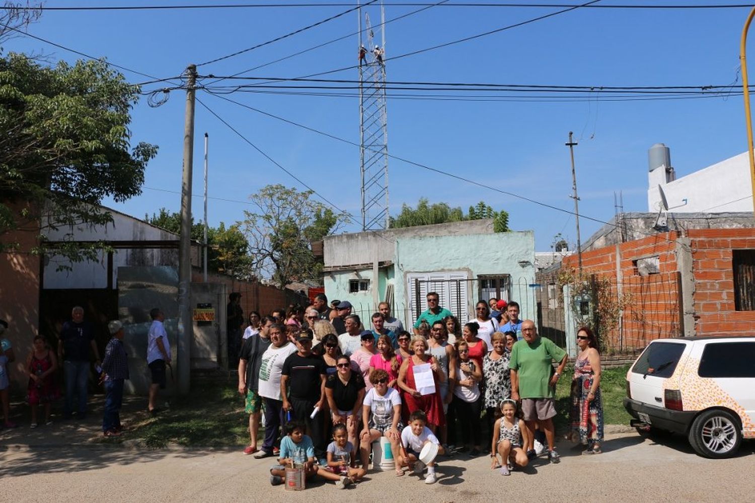 Al frente, los vecinos protestando por la construcción; en el fondo, los operarios levantando la estructura (Archivo)
