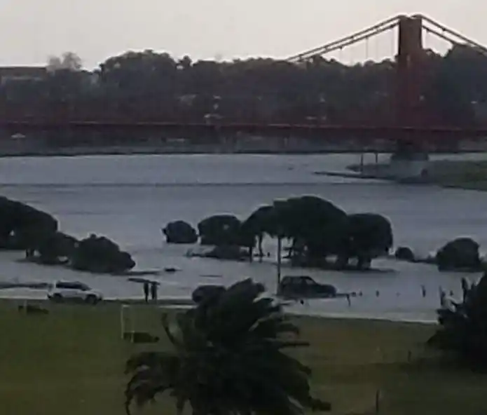 El río casi cubre un auto
