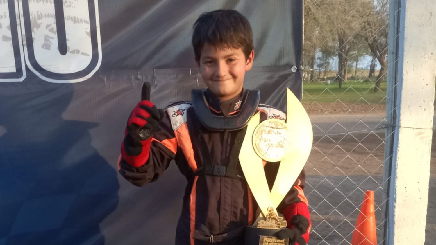 El jóven con su trofeo de campeón.