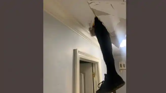 El hombre atravesando el techo con su pierna