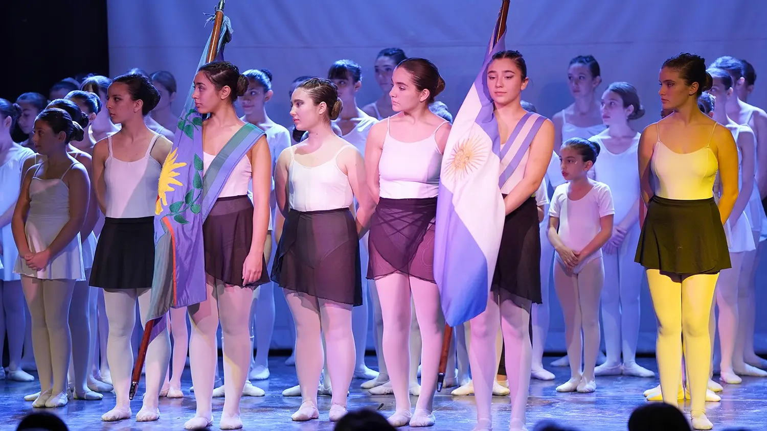 Con las banderas de ceremonia, las alumnas del Instituto en el escenario