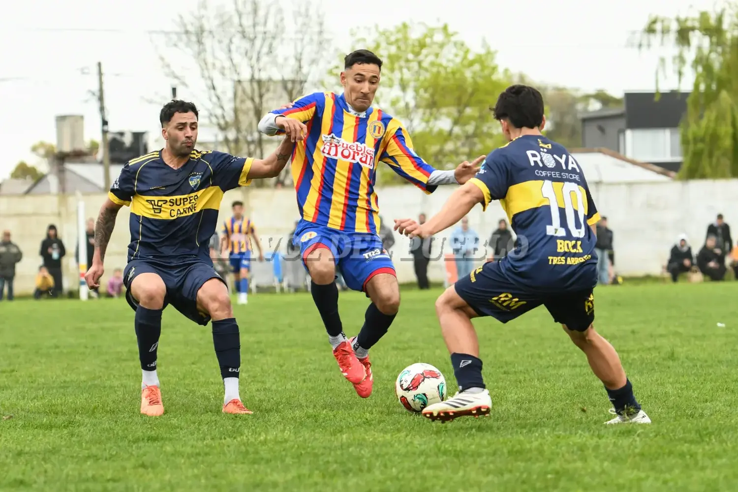 Agustín Barrionuevo de Colegiales va a la disputa de la pelota ante Joaquín Sánchez de Boca (10), lo sostiene desde atrás Lucas Sánchez