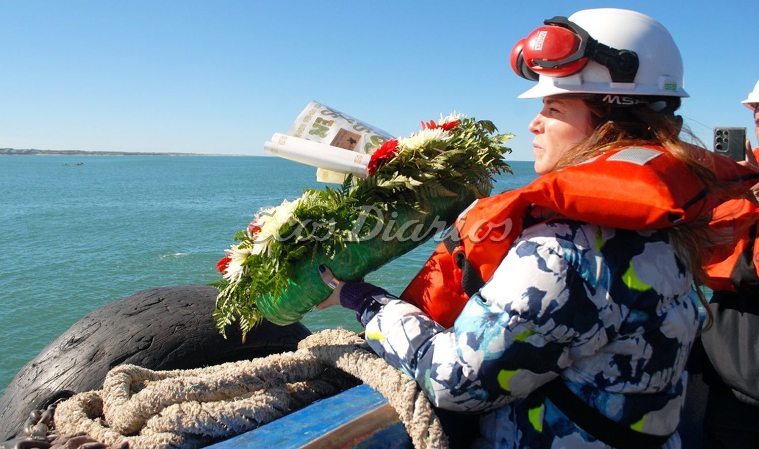 Jimena López.  Arroja al mar una ofrenda, en recuerdo de los  pescadores que perdieran su vida trabajando en el mar