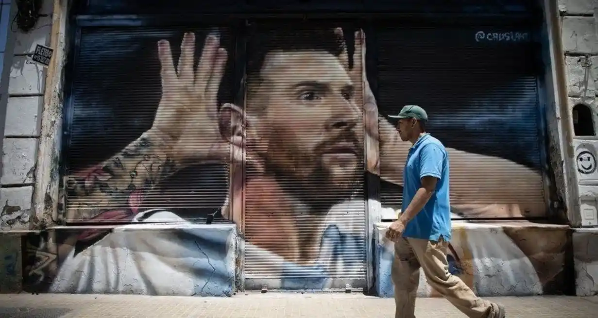 Un hombre camina frente a un mural de Messi realizado sobre la cortina metálica de un local de calle Bolívar al 900, en el barrio de San Telmo, el 30 de diciembre de 2022. Foto: Agencia Xinhua.