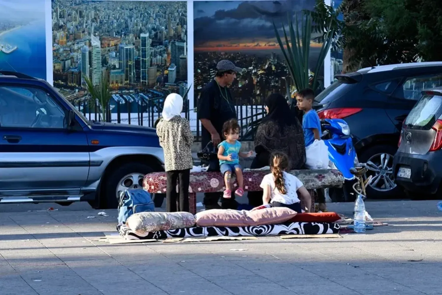 Una familia que ha tenido que abandonar su hogar por los ataques aéreos israelíes permanece en una calle de Beirut. EFE/EPA/Abbas Salman