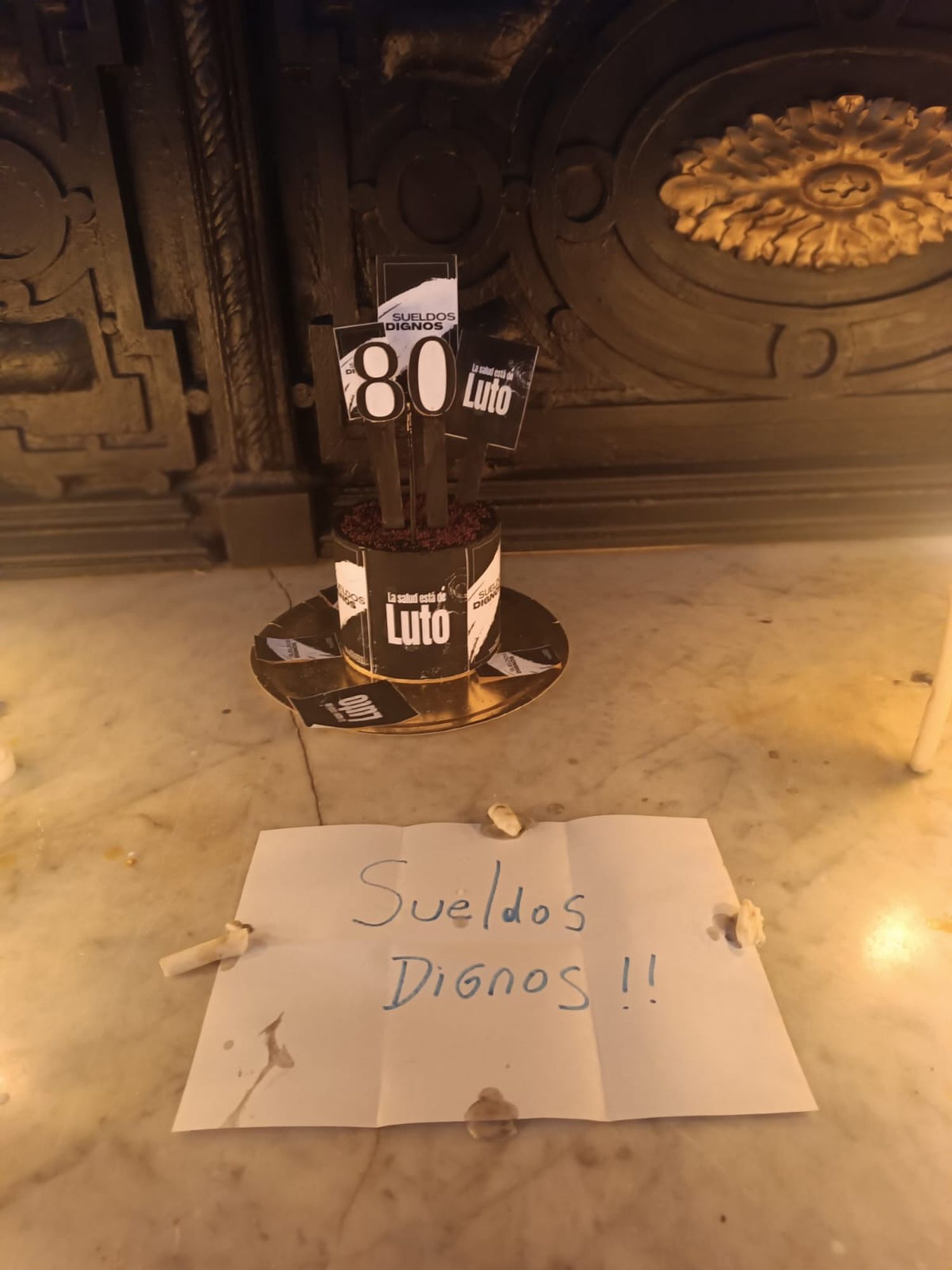 Acompañaron el curioso presente formando con velas el numero 80, y pegando un cartel con las palabras “sueldos dignos”