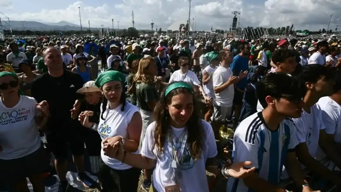 Los jóvenes se toman de las manos durante una misa al aire libre en Roma como parte del Jubileo de la Juventud el 3 de agosto. Filippo Monteforte/AFP/Getty Images