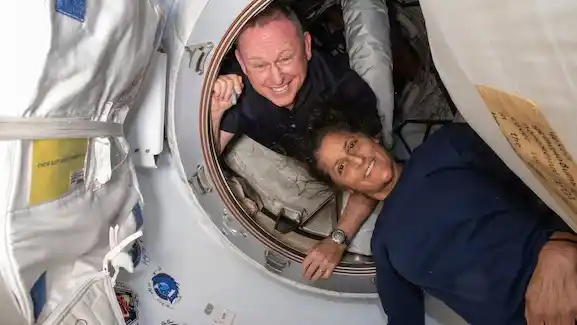 En esta foto, proporcionada por la NASA, los astronautas del Vuelo de Prueba Tripulado de Boeing, Butch Wilmore, izquierda, y Suni Williams, posan para una foto en el vestíbulo entre el puerto delantero del módulo Harmony de la Estación Espacial Internacional y la nave espacial Starliner, el 13 de junio de 2024