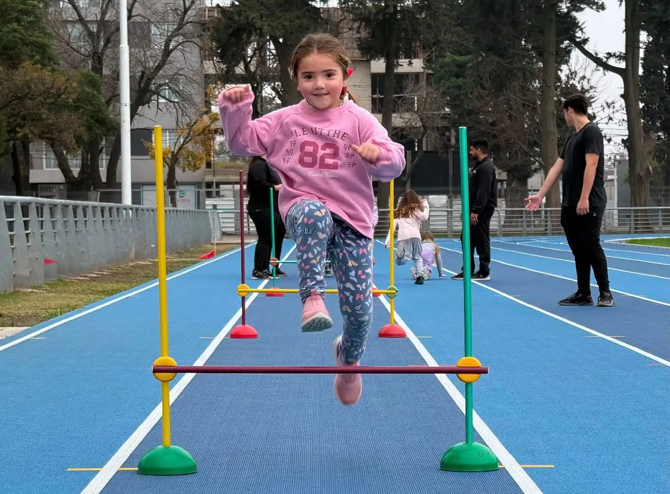 Una de las niñas disfrutando de la actividad en la pista de atletismo.