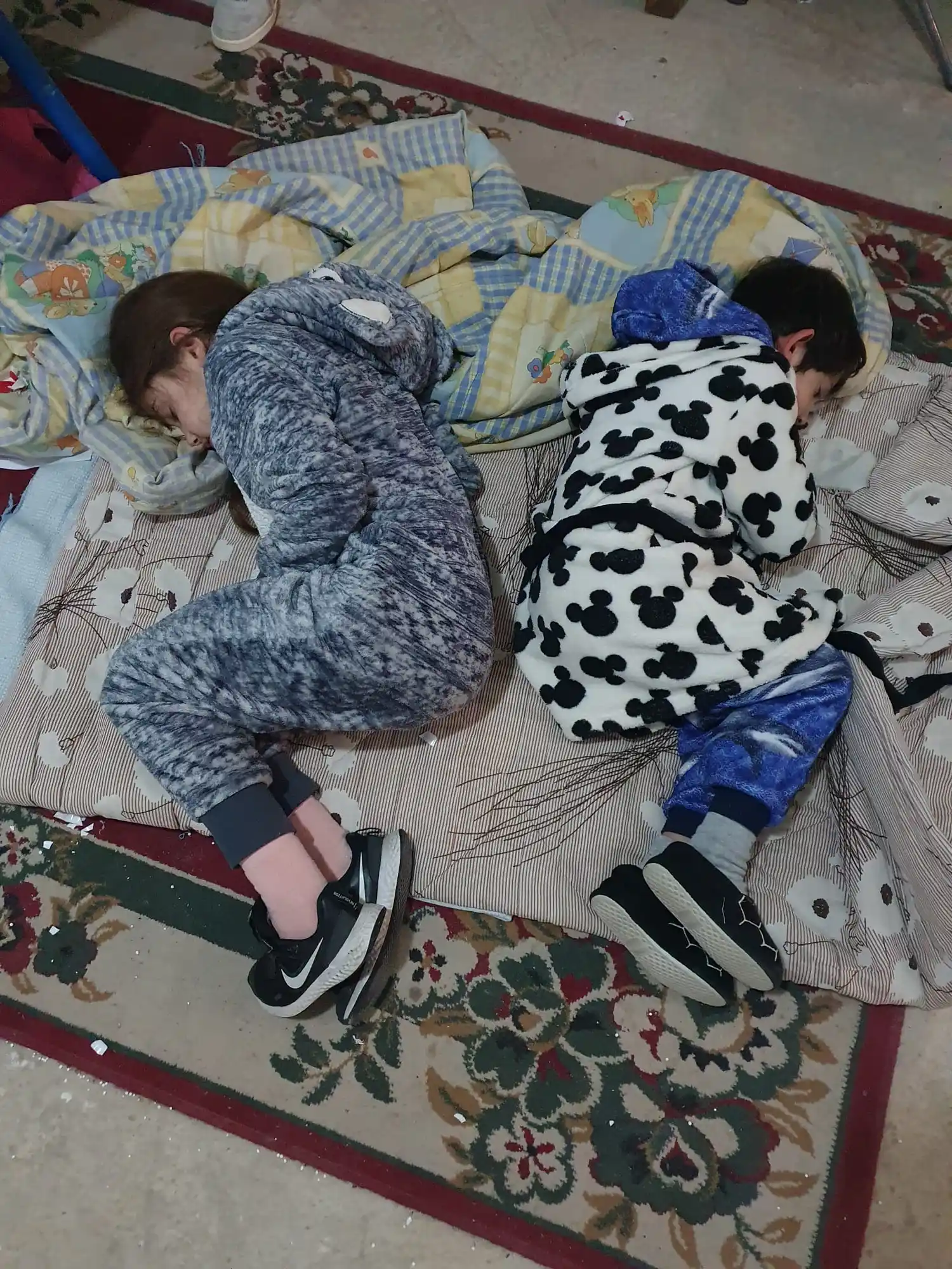 Sus hijos  pequeños durmiendo en el refugio cuando suenan las alarmas de noche-