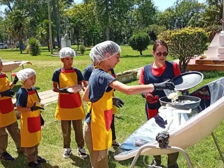Los chicos aprenden con la cocina solar, bajo la mirada atenta de una docente. Foto: Gentileza