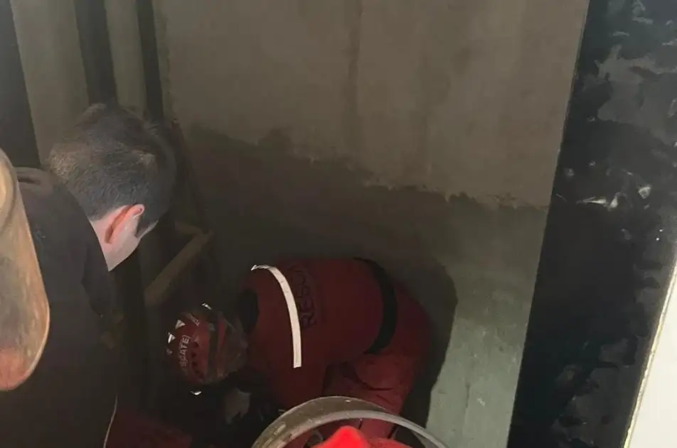 Los rescatistas trabajaron para extraer el cuerpo del hueco del ascensor.