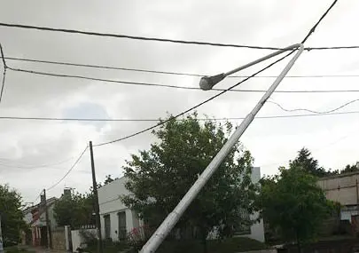 Un peligro, un palo de luz agarrado solo de los cables